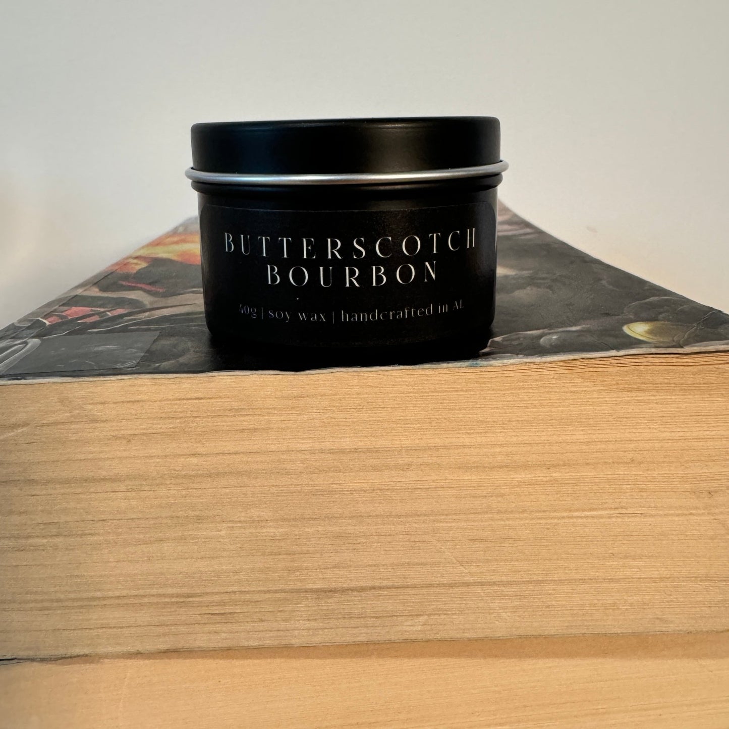 “Butterscotch Bourbon” small tin candle — a magical gift for book lovers and Harry Potter fans, styled with wizarding charm.