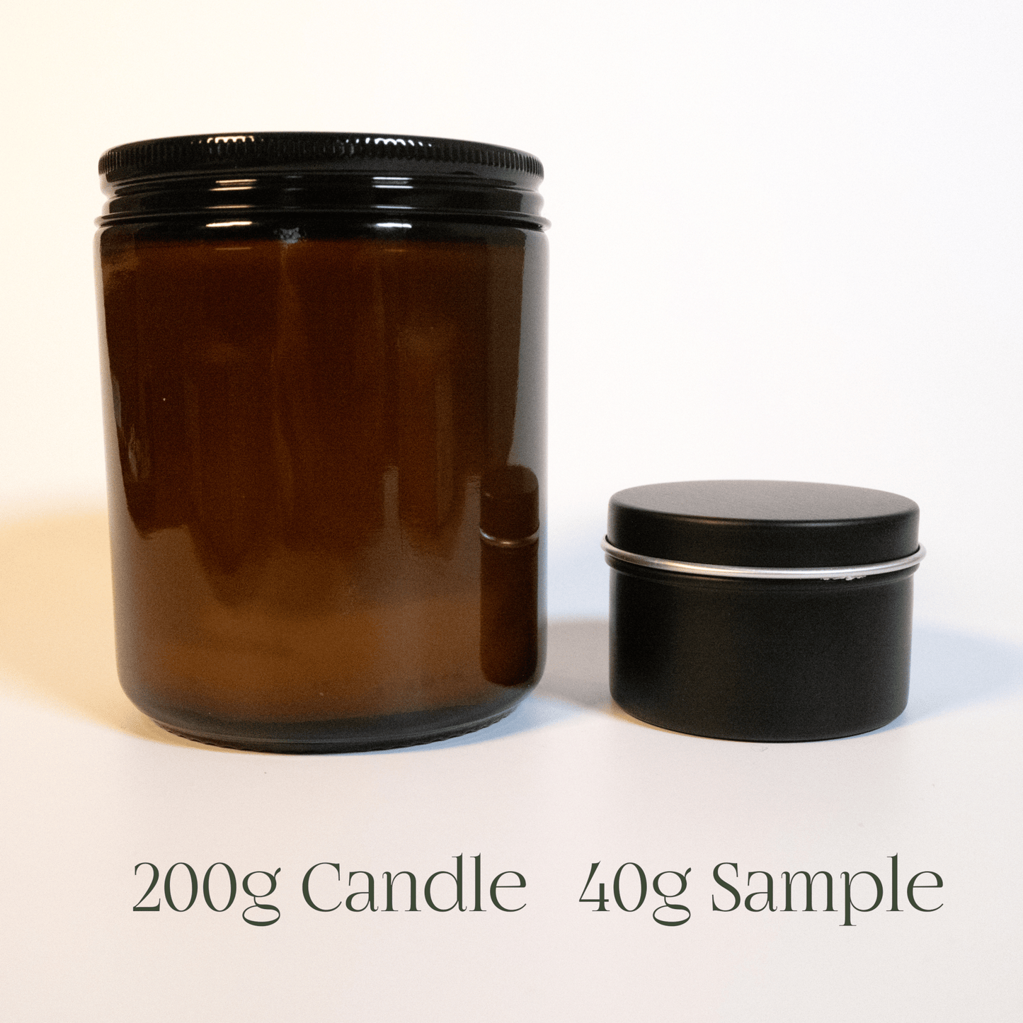 Size comparison of a full-size 200g glass candle jar vs a 40g sample tin candle.