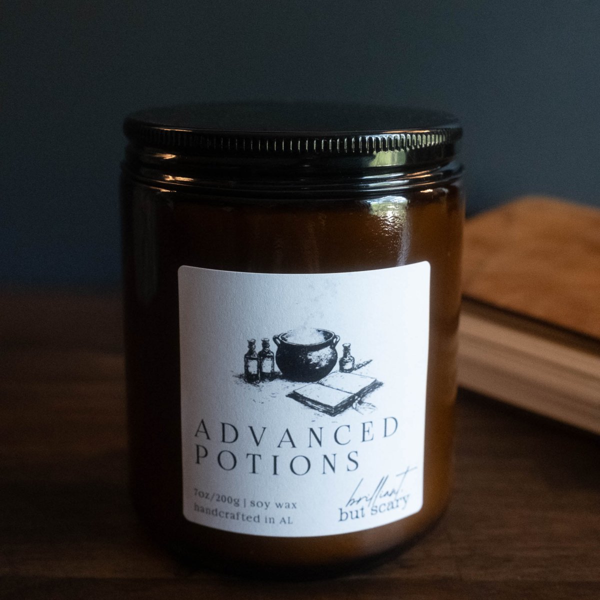 Jar of 'Advanced Potions' candle with a label on a dark background